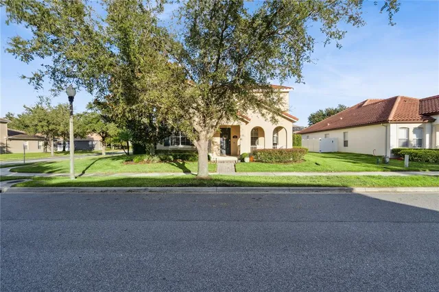 a view of a house with a big yard and large trees