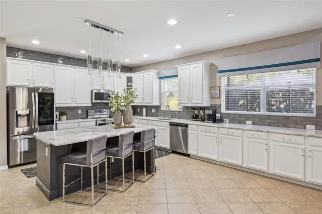 a large kitchen with kitchen island granite countertop a counter top space appliances and cabinets
