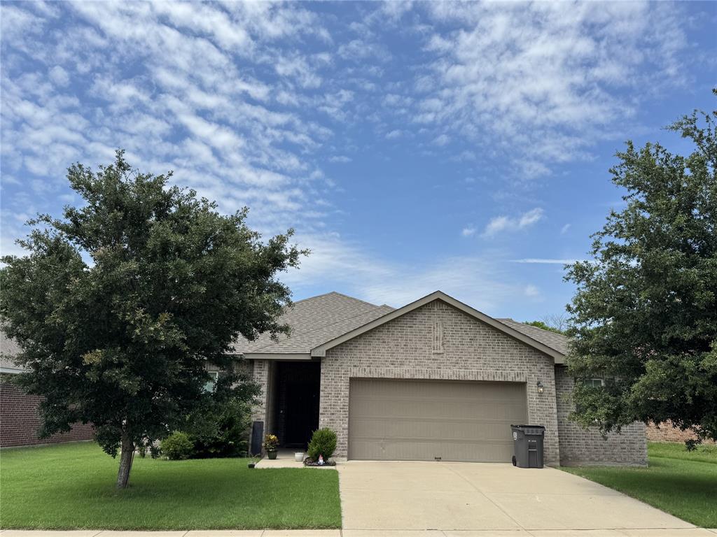2209 Cinnamon Spgs Road Glenn Heights, TX 75154 - Photo 25 of 28 Brick exterior with a gabled roofline, front-facing garage, concrete driveway, and established trees