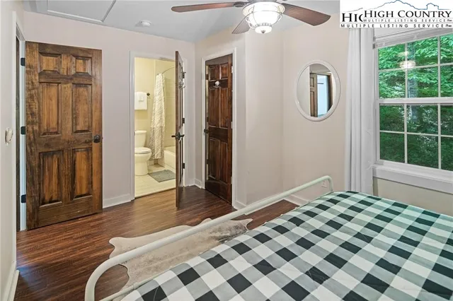 a bedroom with a bed chandelier and a window