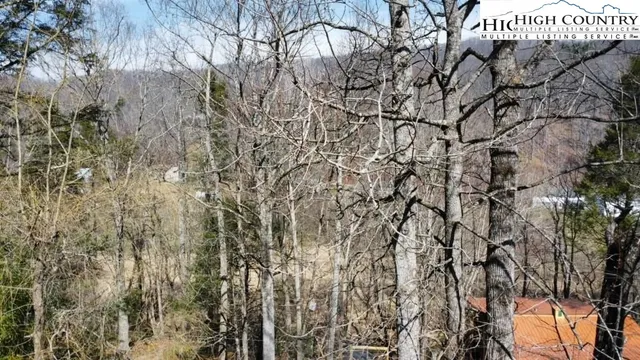 an aerial view of residential house with outdoor space and trees all around