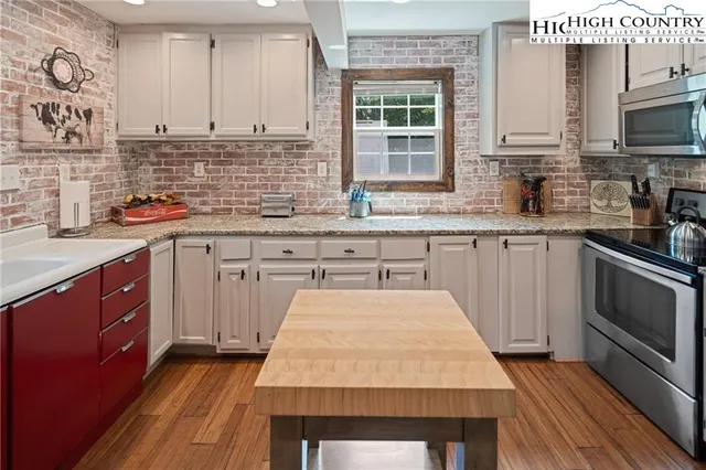 a kitchen with stainless steel appliances granite countertop a refrigerator sink and stove