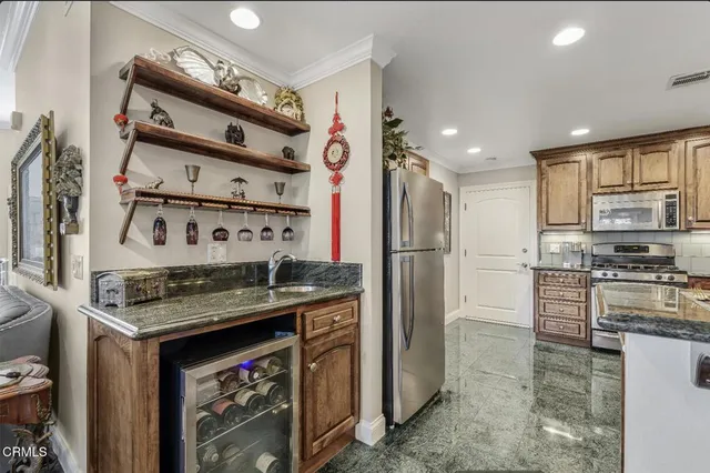 a kitchen with stainless steel appliances granite countertop a stove a refrigerator and a refrigerator