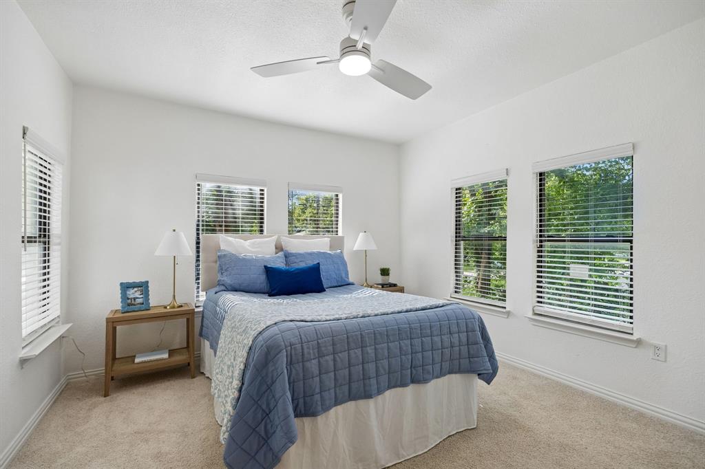 806 North Ruddell Street Denton, TX 76209 - Photo 22 of 26 a bedroom with a large bed and a chandelier fan