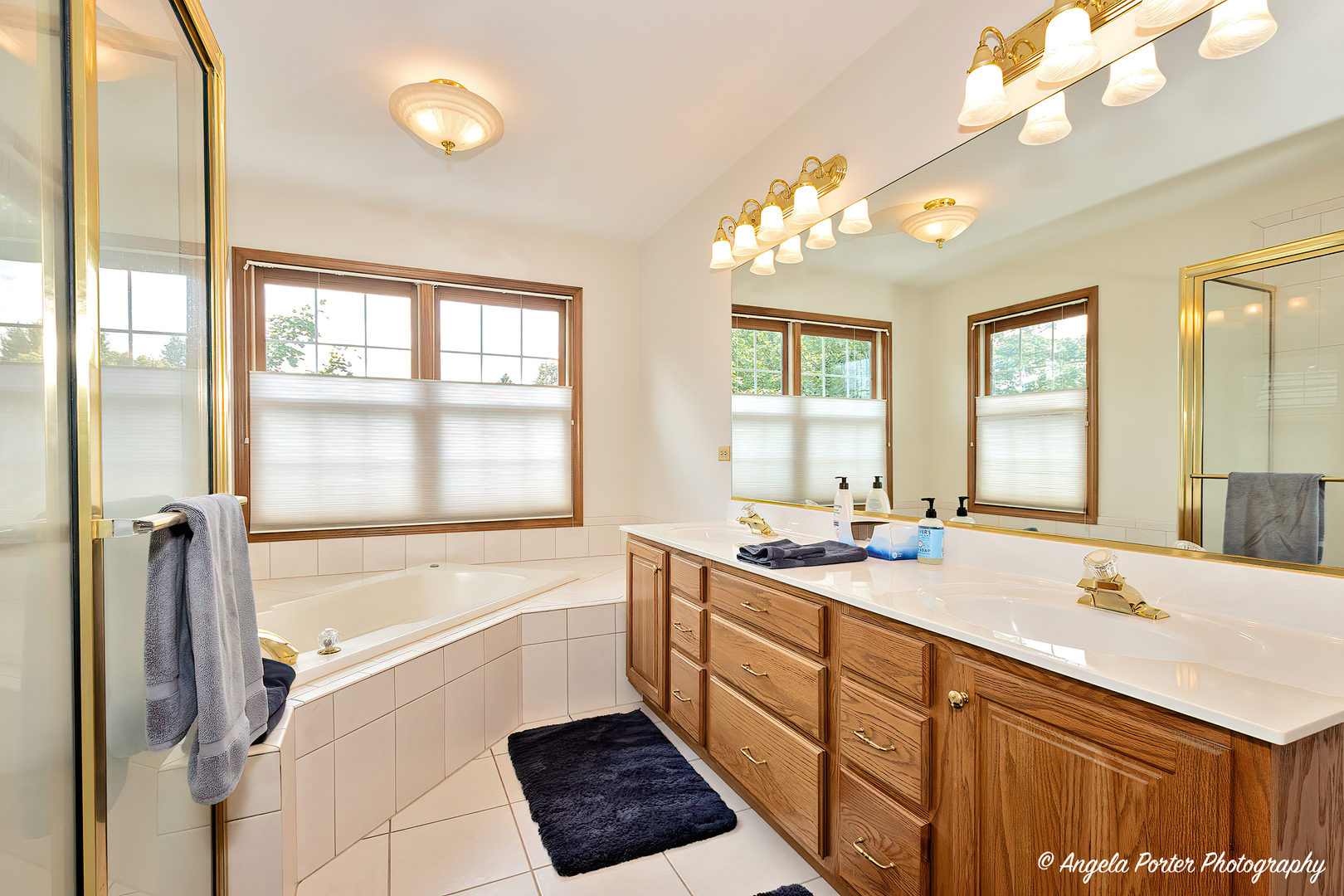 471 White Oaks Drive Cary, IL 60013 - Photo 29 of 39 a bathroom with a sink a large mirror and a bathtub with shower