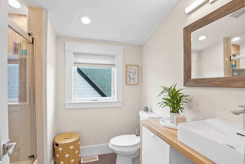 340 Main Street Everett, MA 02149 - Photo 23 of 42 a bathroom with a sink a toilet a potted plant and a mirror