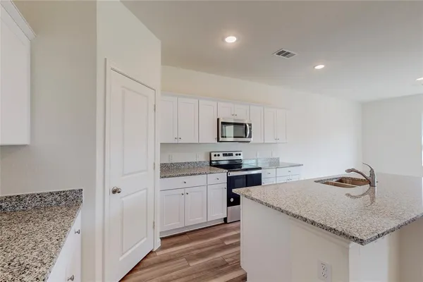 a kitchen with a white wooden cabinets and stainless steel appliances