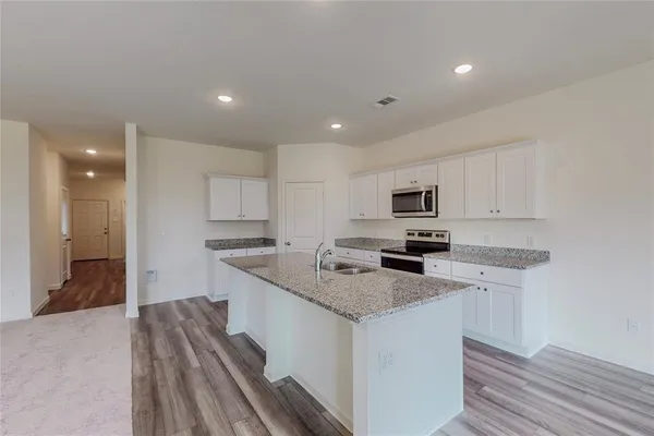 a view of kitchen with kitchen island sink and stove