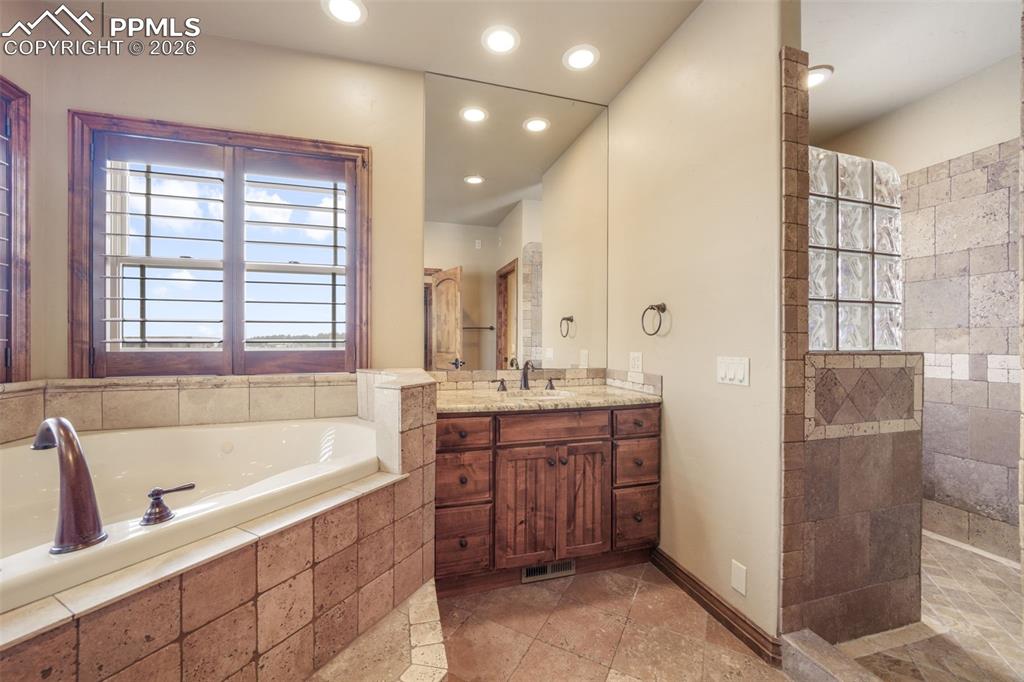 7830 Tannenbaum Road Colorado Springs, CO 80908 - Photo 25 of 50 a bathroom with a tub sink shower and mirror