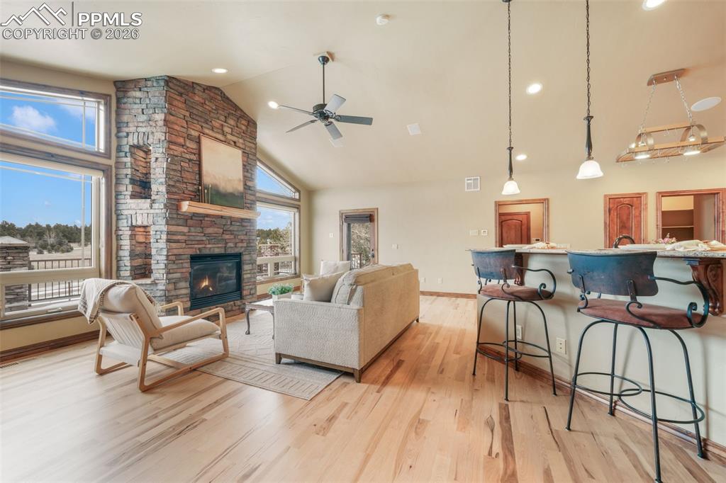 7830 Tannenbaum Road Colorado Springs, CO 80908 - Photo 10 of 50 a living room with furniture a fireplace and a floor to ceiling window