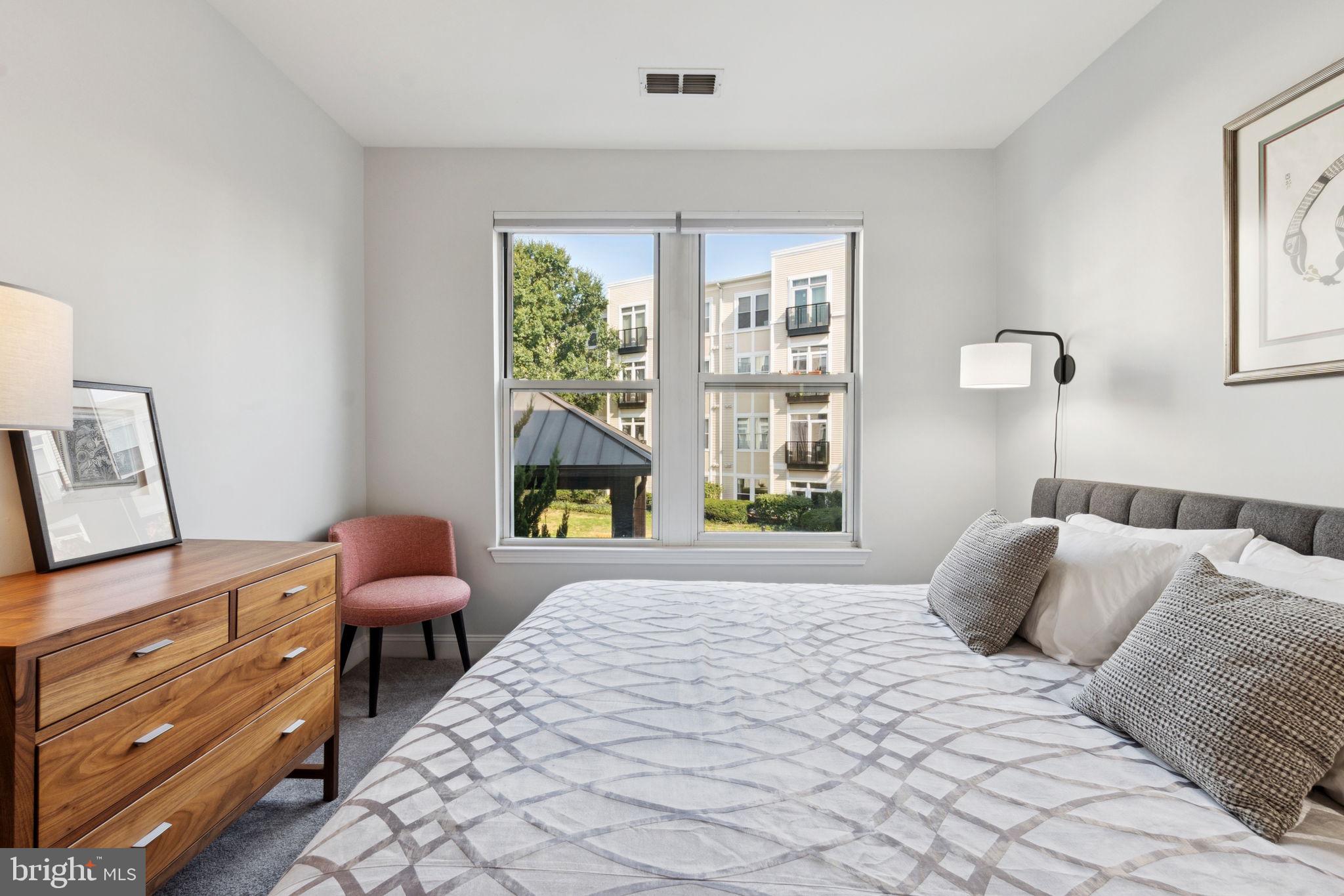 1391 Pennsylvania Ave. Southeast, Unit 352 Washington, DC 20003 - Photo 15 of 43 a bedroom with a bed a lamp and a window