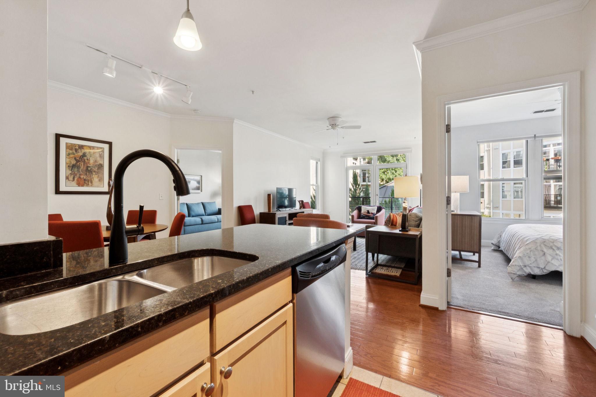 1391 Pennsylvania Ave. Southeast, Unit 352 Washington, DC 20003 - Photo 9 of 43 a kitchen with a sink chairs and a dining table with wooden floor