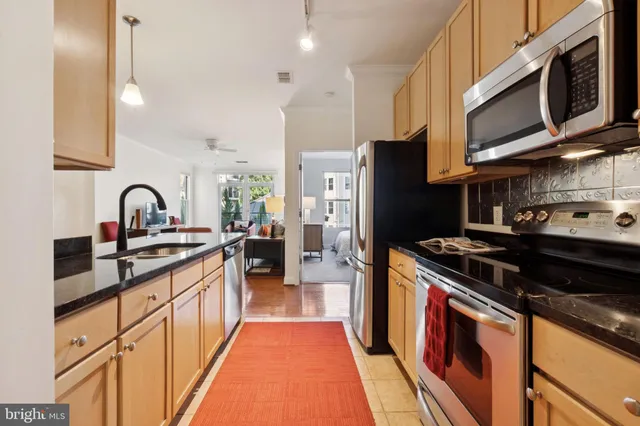 a kitchen with stainless steel appliances granite countertop a stove a sink dishwasher and a refrigerator