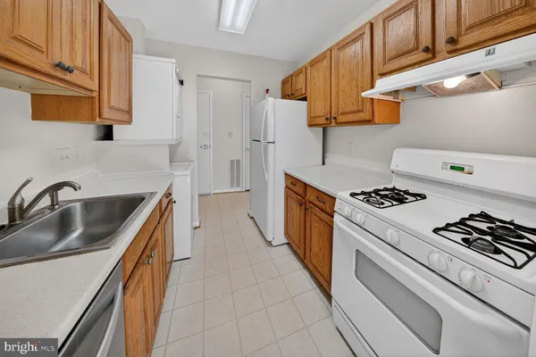 a kitchen with granite countertop a sink stove and cabinets