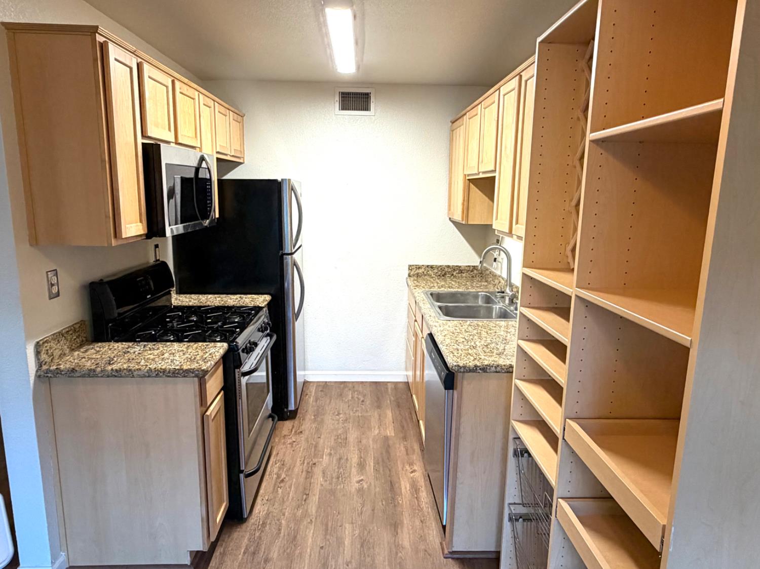 5000 Bremner Way, Unit 4 Sacramento, CA 95841 - Photo 2 of 23 a kitchen with stainless steel appliances granite countertop a refrigerator a stove and a sink with wooden floor