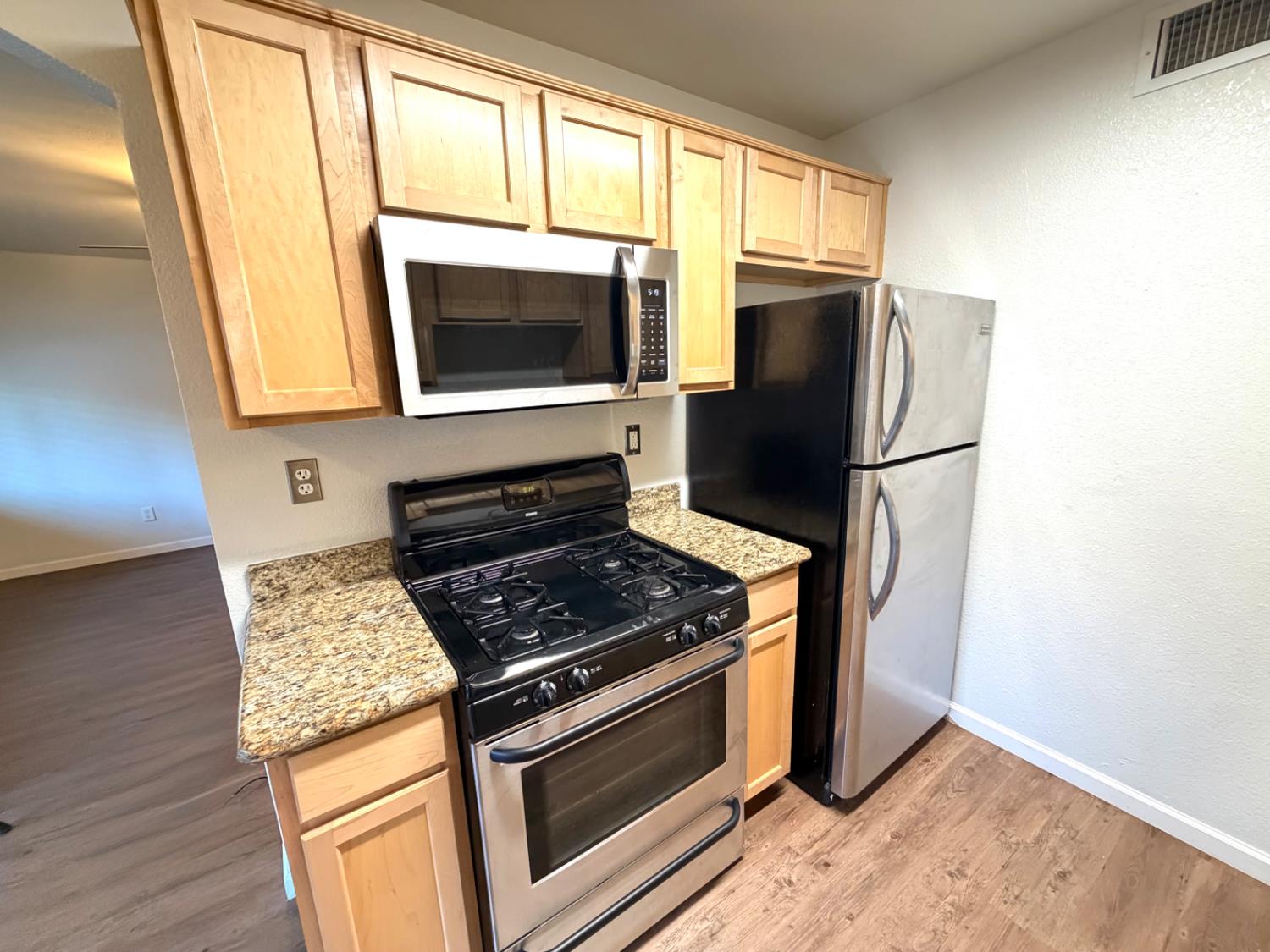 5000 Bremner Way, Unit 4 Sacramento, CA 95841 - Photo 5 of 23 a kitchen with granite countertop wooden cabinets and a stove top oven