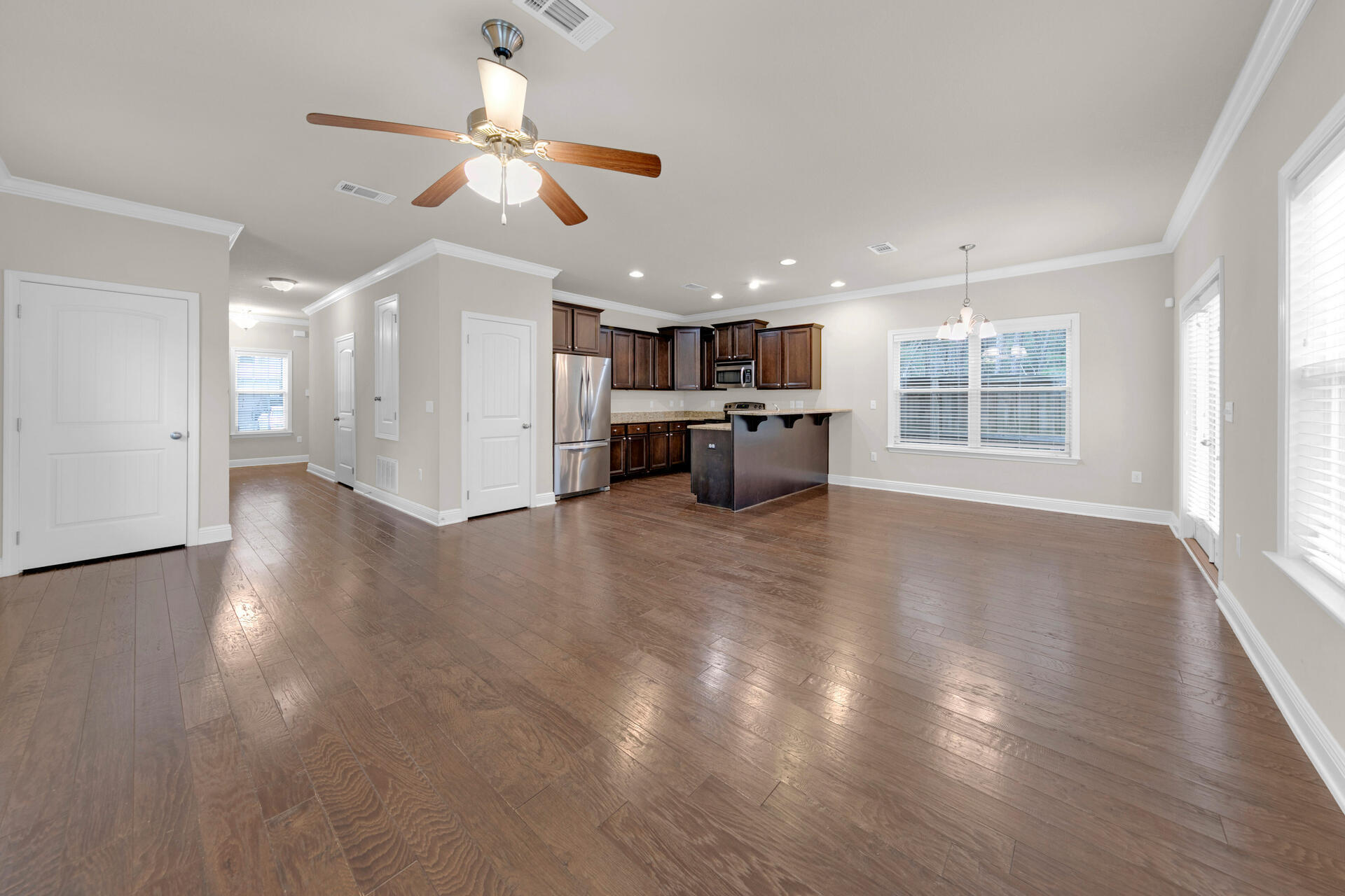 40 Horn Beam Way Santa Rosa Beach, FL 32459 - Photo 9 of 37 a living room with stainless steel appliances kitchen island granite countertop a refrigerator a stove a sink and a large window with wooden floor