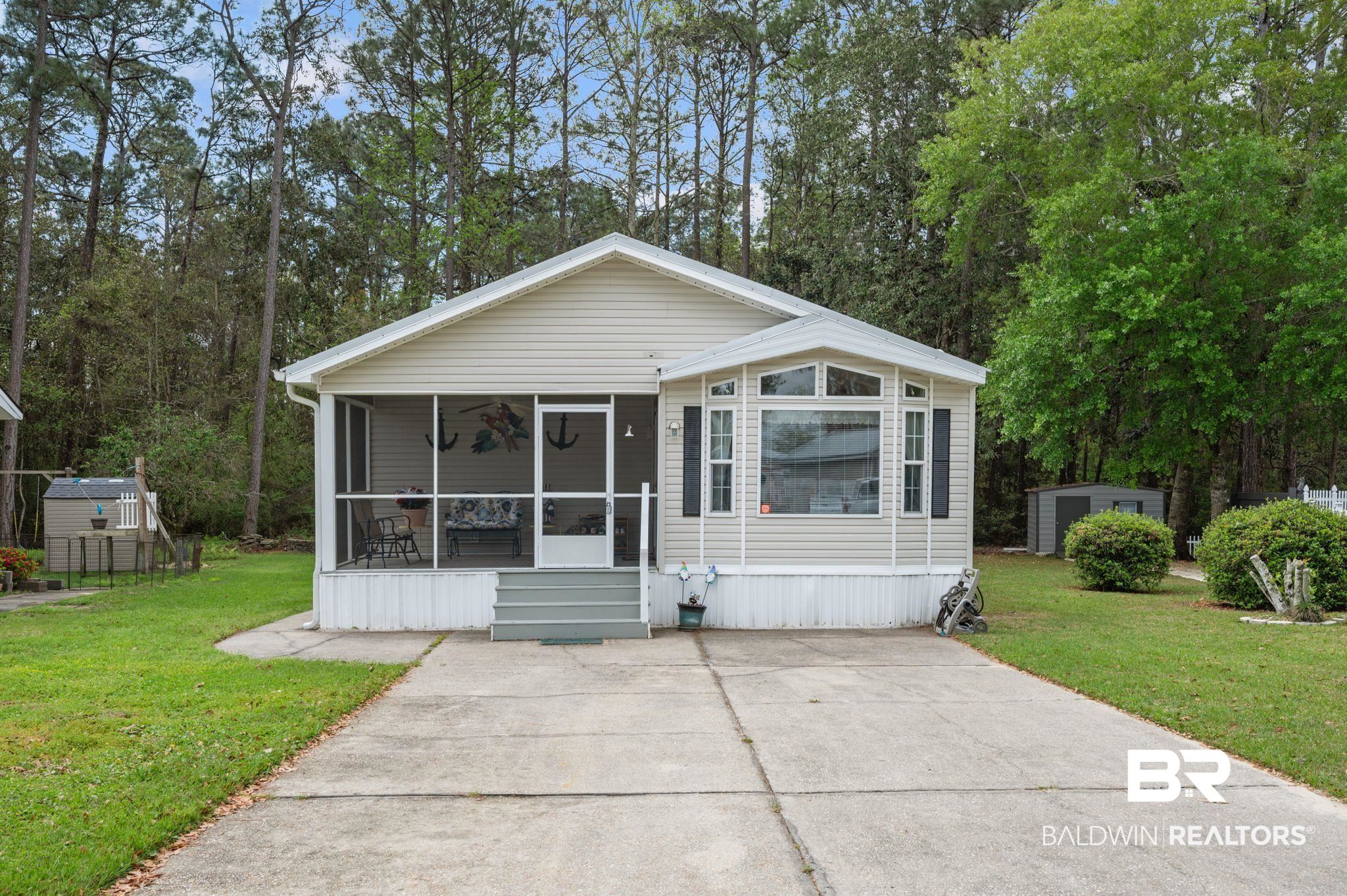 24711 County Road 20, Unit A11 Elberta, AL 36530 - Photo 1 of 35 Manufactured / mobile home featuring a front lawn, a sunroom, and view of scattered trees