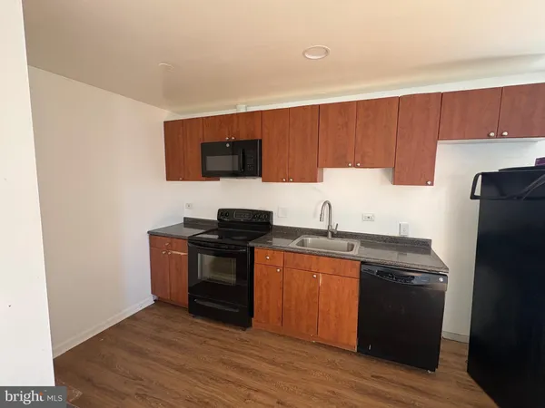 a kitchen with granite countertop a refrigerator stove and sink