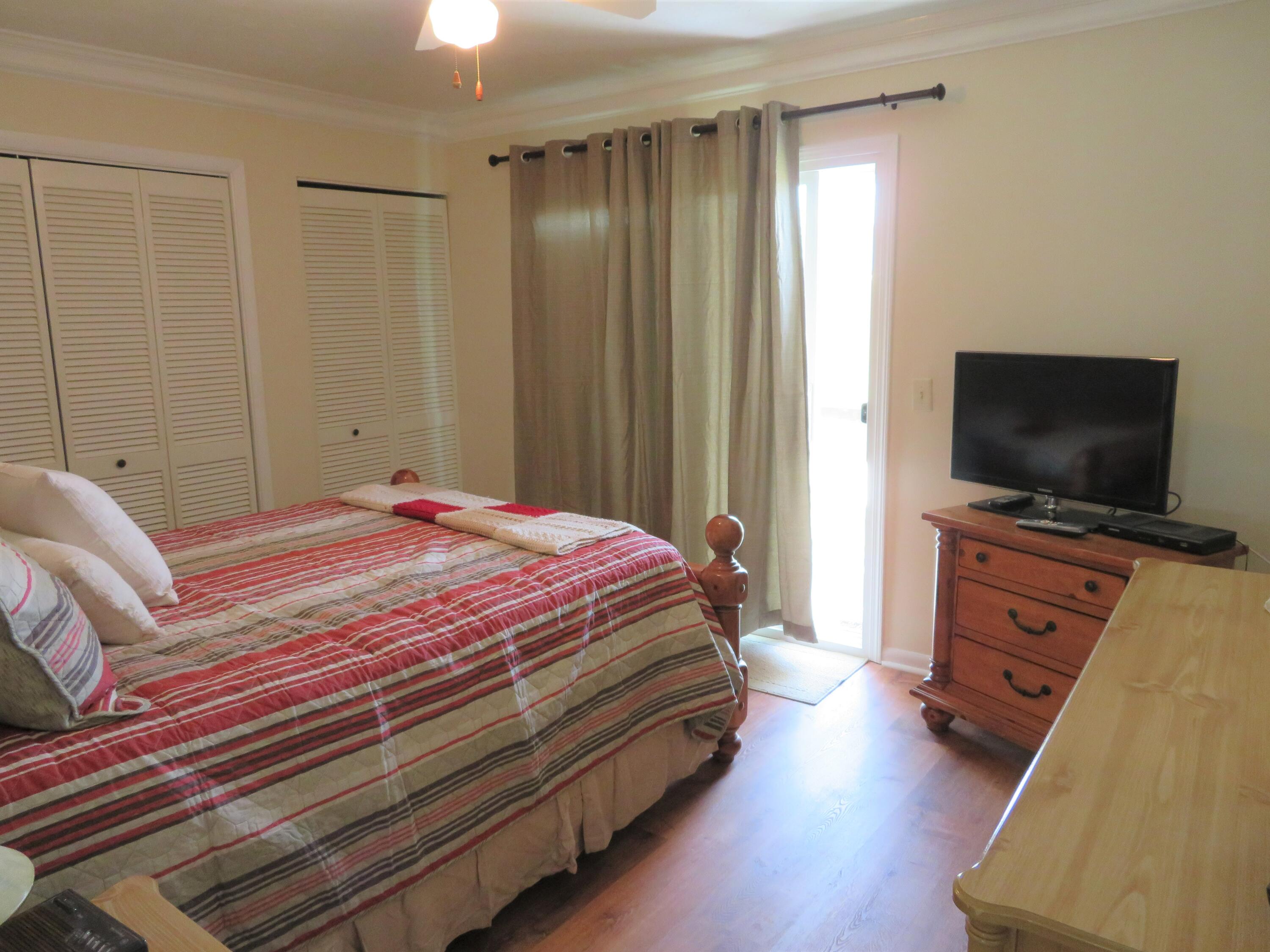17670 Front Beach Road, Unit B4 Panama City Beach, FL 32413 - Photo 9 of 14 a bedroom with a bed and a flat tv screen on wall
