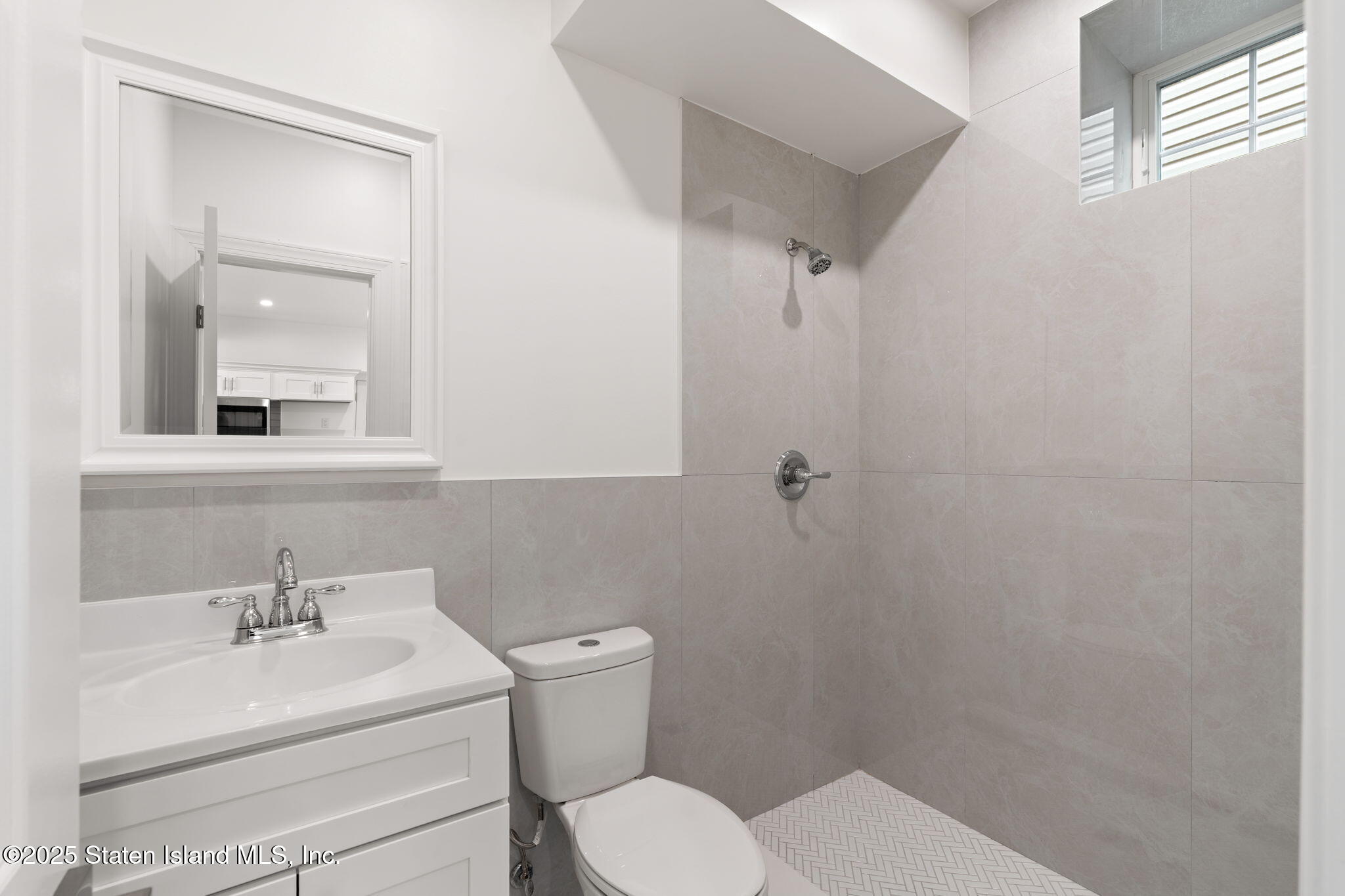 1384 Clove Road Staten Island, NY 10301 - Photo 24 of 51 a bathroom with a toilet a sink a mirror and vanity