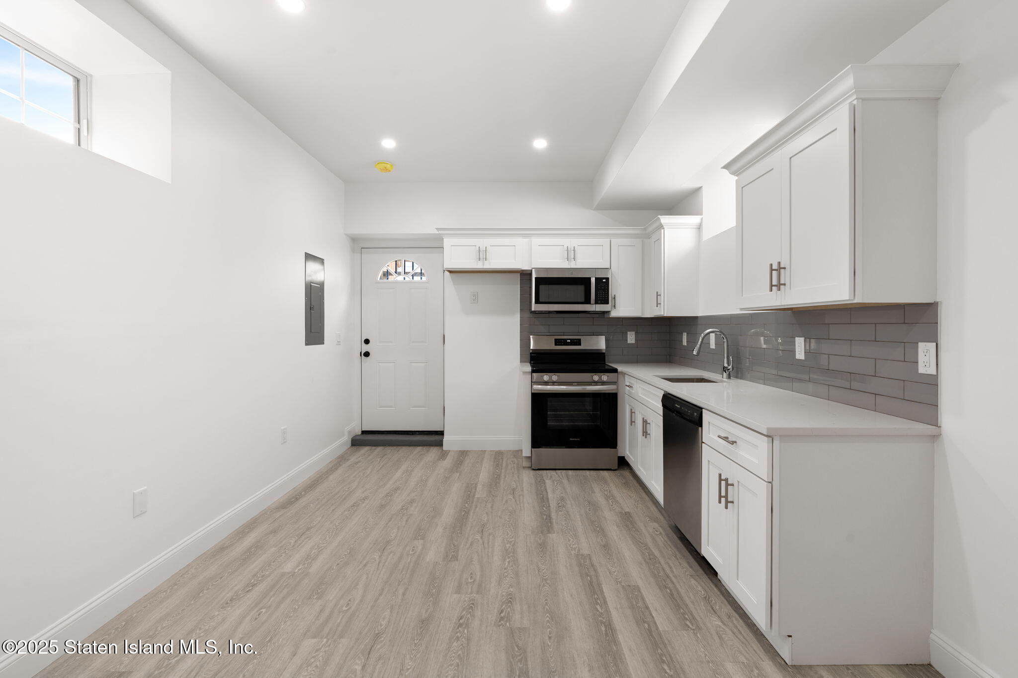 1384 Clove Road Staten Island, NY 10301 - Photo 26 of 51 a kitchen with granite countertop white cabinets and stainless steel appliances