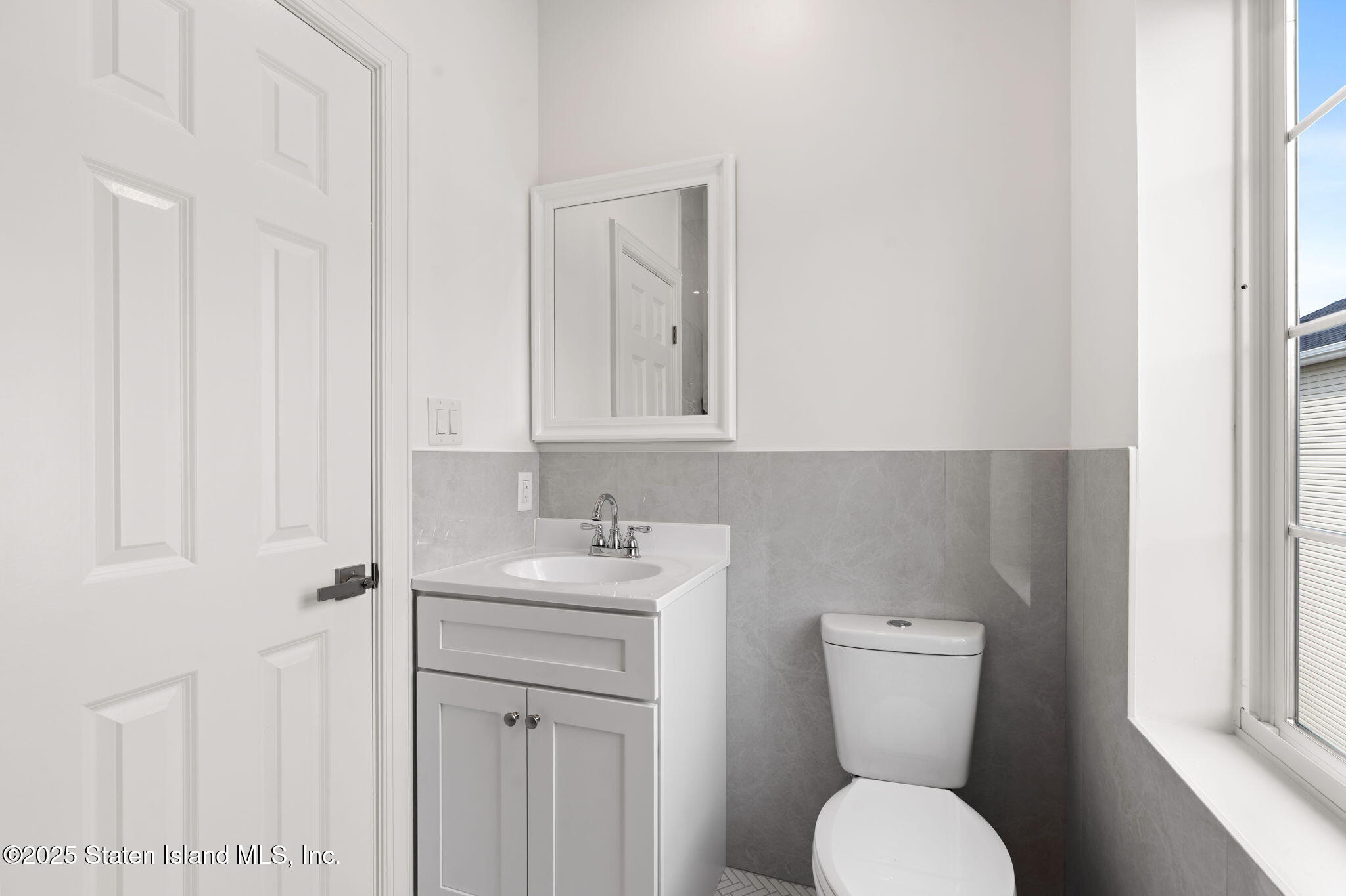 1384 Clove Road Staten Island, NY 10301 - Photo 32 of 51 a bathroom with a toilet a sink and mirror