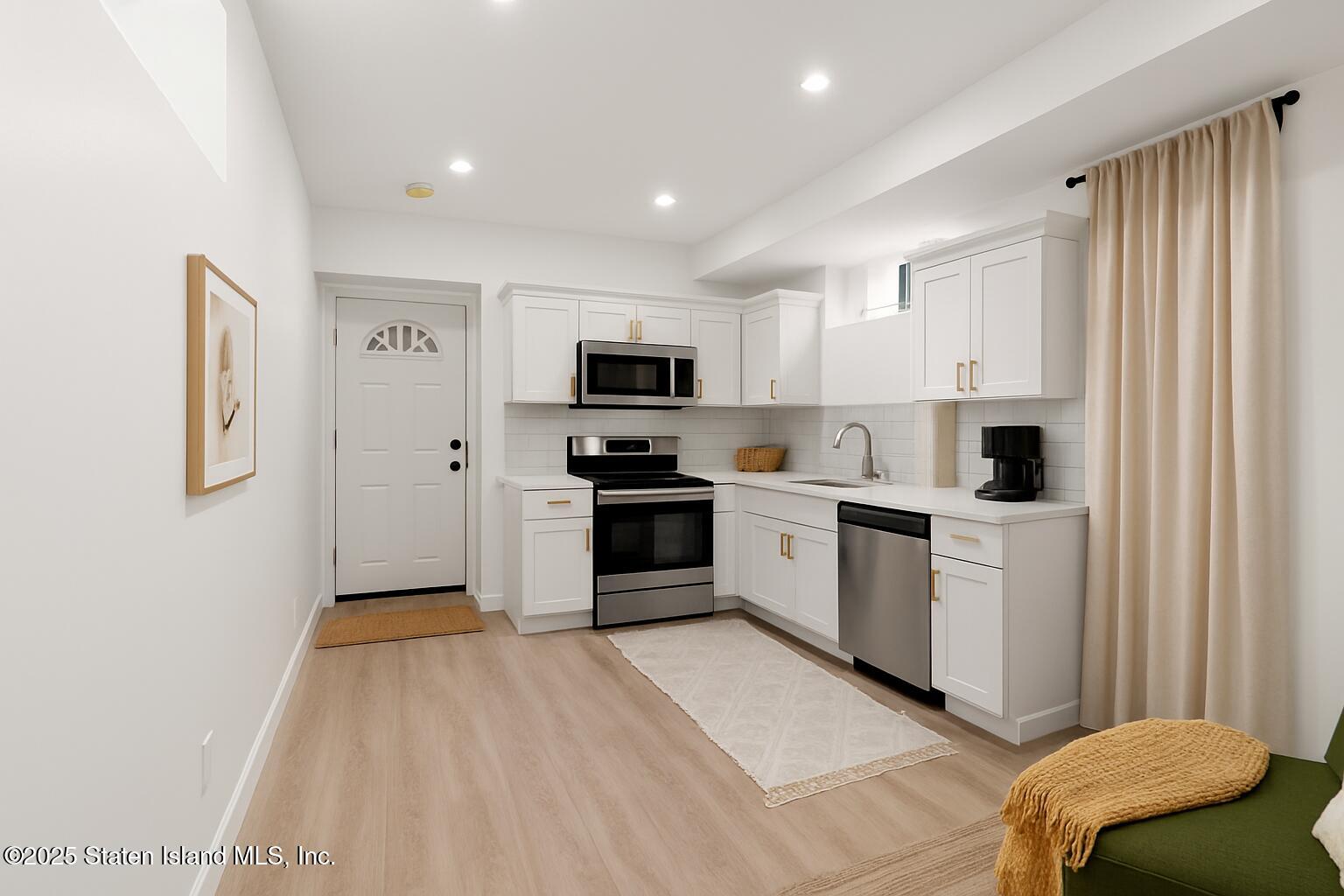 1384 Clove Road Staten Island, NY 10301 - Photo 48 of 51 a kitchen with white cabinets and stainless steel appliances
