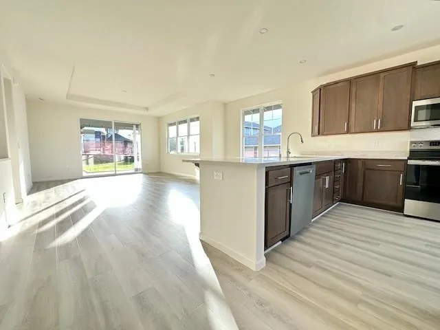 a large kitchen with stainless steel appliances granite countertop a stove and a sink