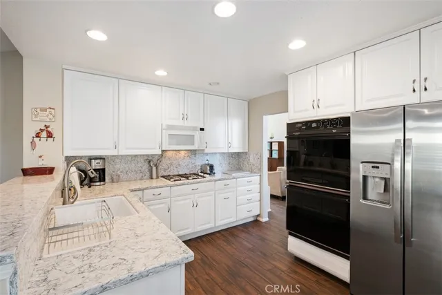 a kitchen with a refrigerator sink and cabinets