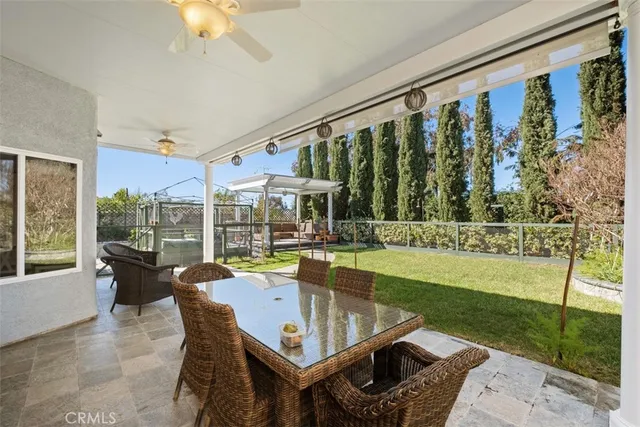 a view of a chair and tables in the patio in front of a house