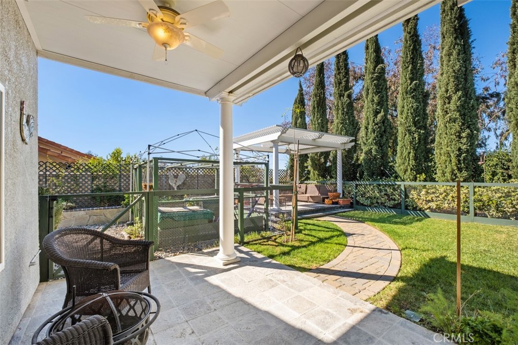 20891 Porter Ranch Road Rancho Santa Margarita, CA 92679 - Photo 32 of 40 a view of a chair and tables in the patio in front of a house