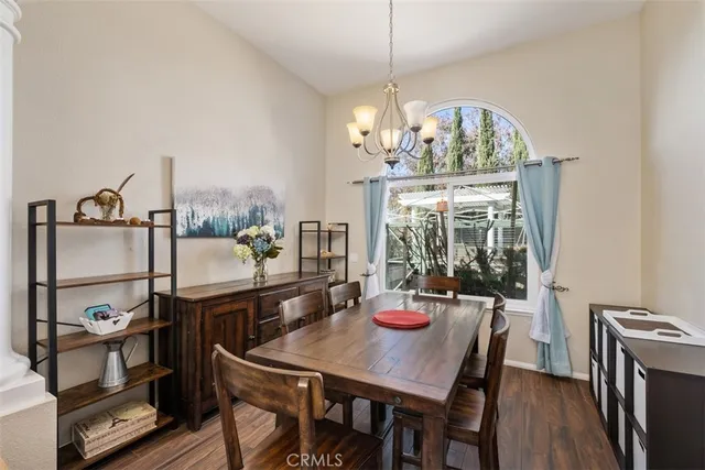 a view of a dining room with furniture a chandelier and wooden floor