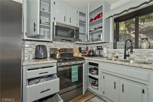 a kitchen with stainless steel appliances granite countertop a sink and stove