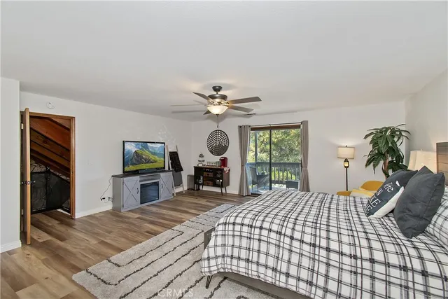 a spacious bedroom with a bed and a flat screen tv