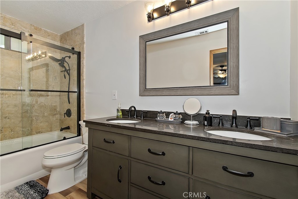 198 Zermatt Drive Crestline, CA 92325 - Photo 33 of 54 a bathroom with a granite countertop toilet a sink and mirror