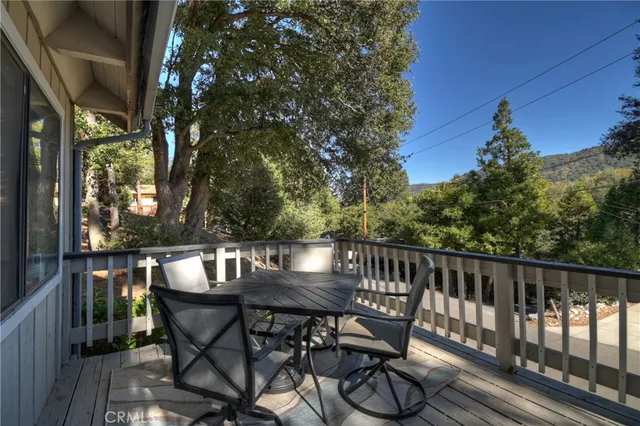 a view of balcony with table and chairs and wooden fence