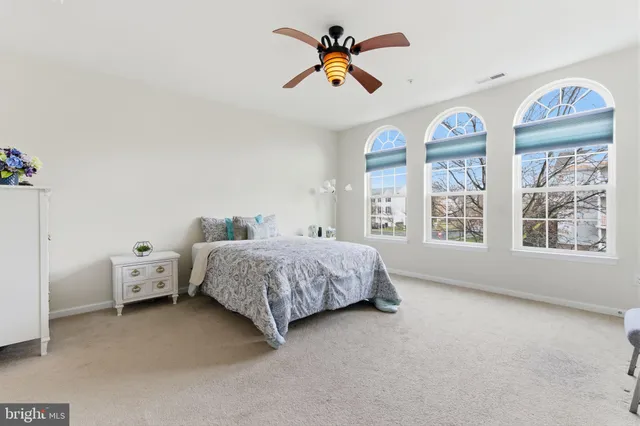 a spacious bedroom with a bed and a chandelier