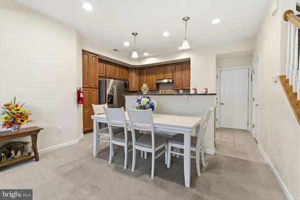 a kitchen with kitchen island a dining table chairs and a refrigerator