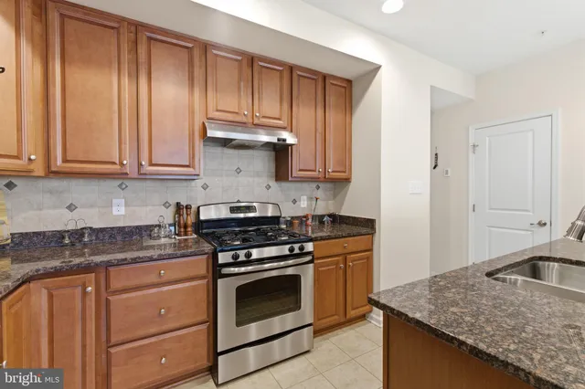 a kitchen with granite countertop cabinets stainless steel appliances and wooden cabinets