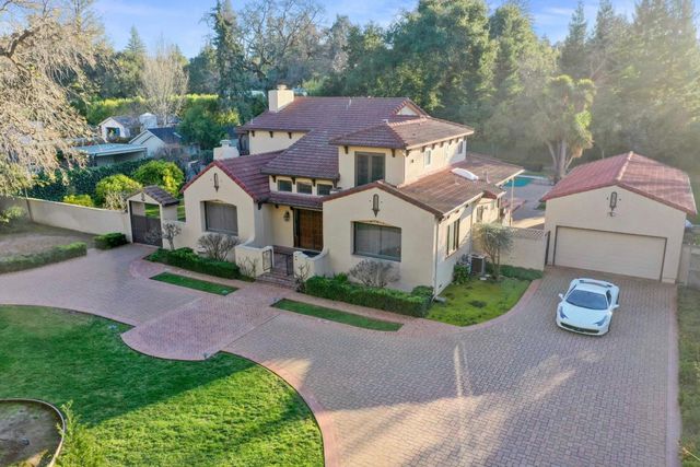 a front view of a house with a garden and plants