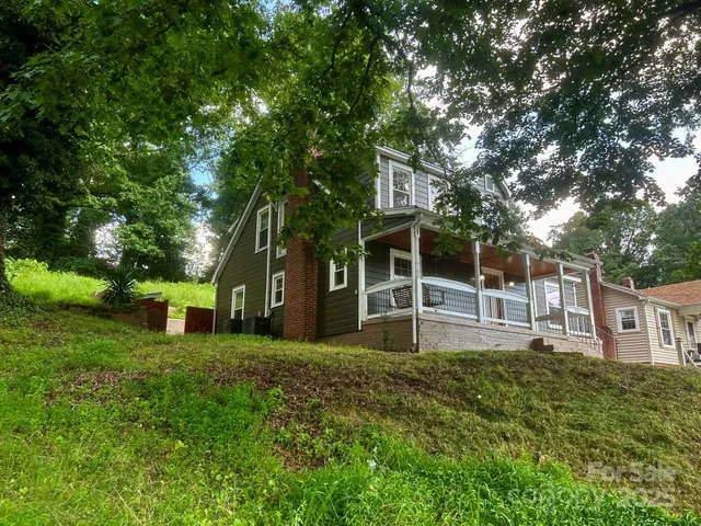 a view of a house with a yard and sitting area