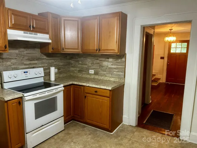 a kitchen with a stove a sink and a window