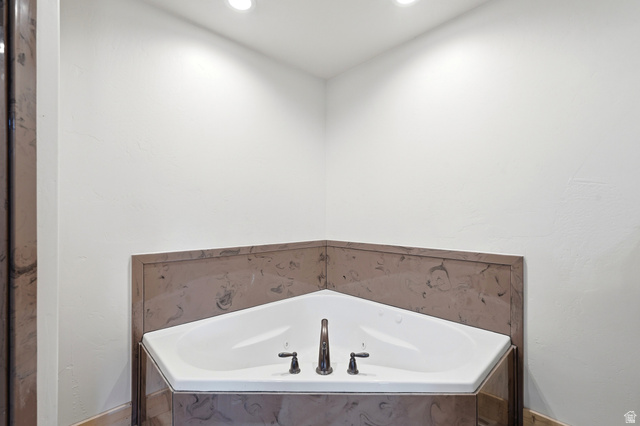 306 Spring Road Preston, ID 83263 - Photo 19 of 55 Corner soaking tub with a dark bronze faucet and separate handles