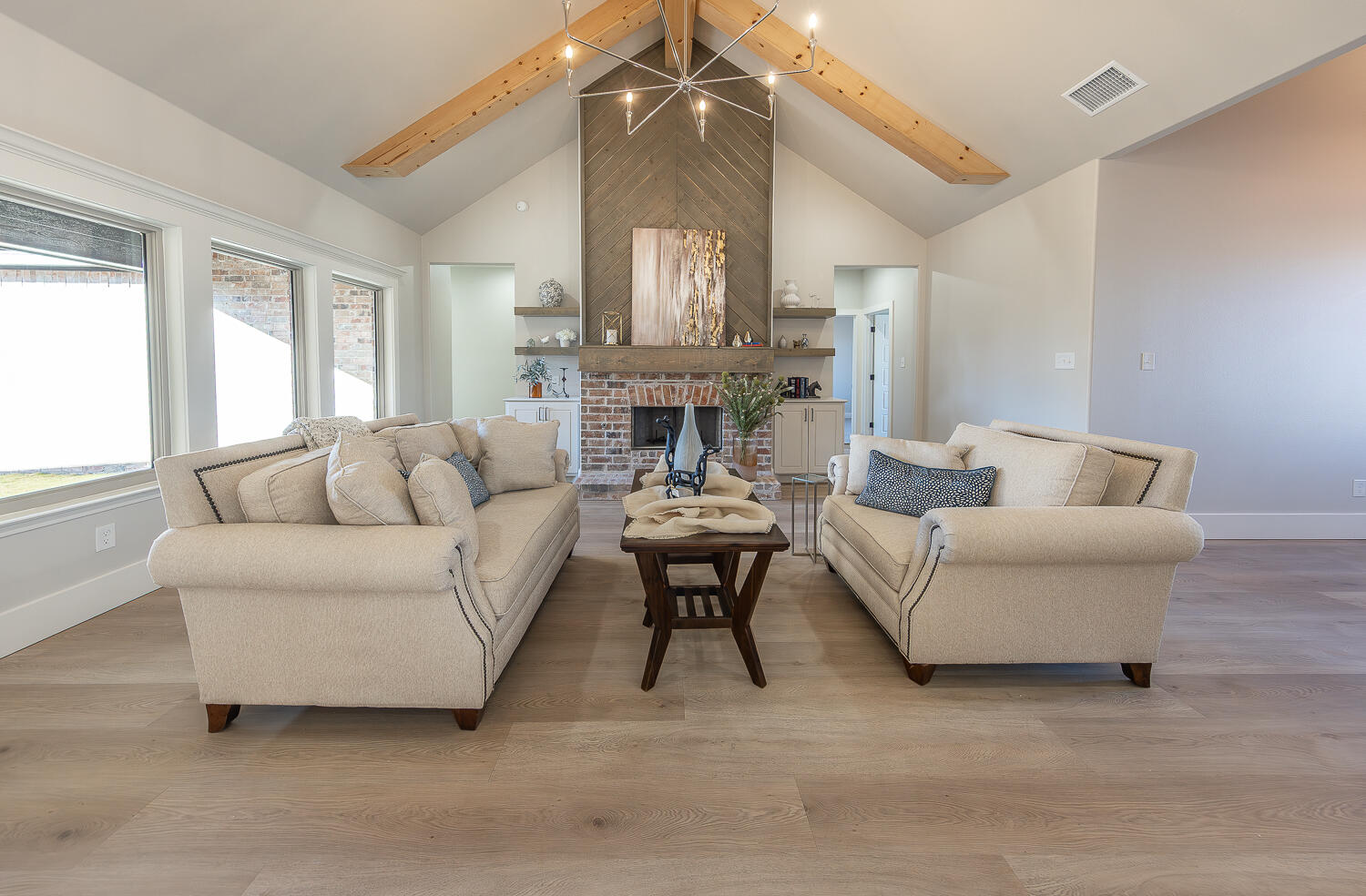 3607 143rd Street Lubbock, TX 79423 - Photo 2 of 35 a living room with furniture a fireplace and a chandelier