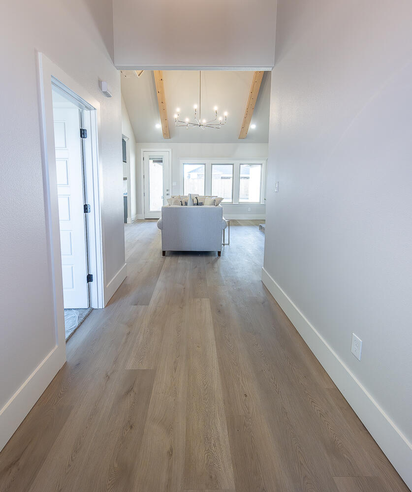 3607 143rd Street Lubbock, TX 79423 - Photo 4 of 35 a view of a hallway with wooden floor and a kitchen space