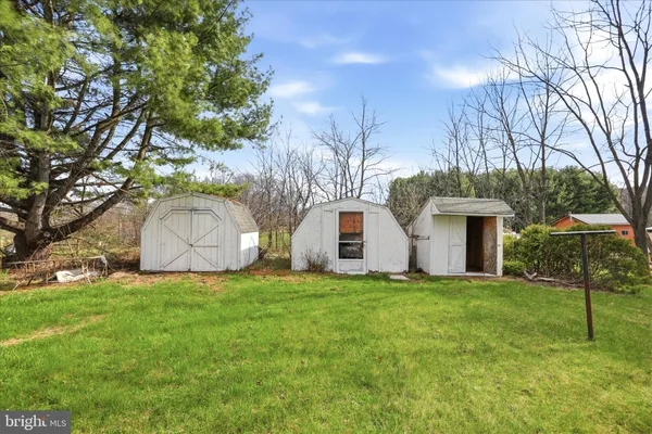 a front view of house with yard and trees in the background