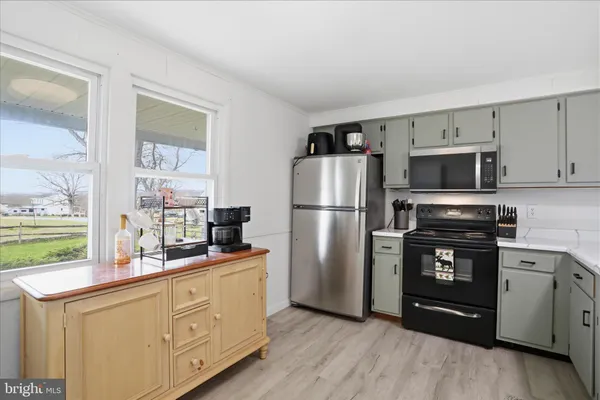 a kitchen with granite countertop a refrigerator stove and sink