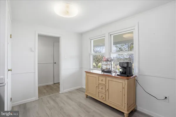 a kitchen with white cabinets and window