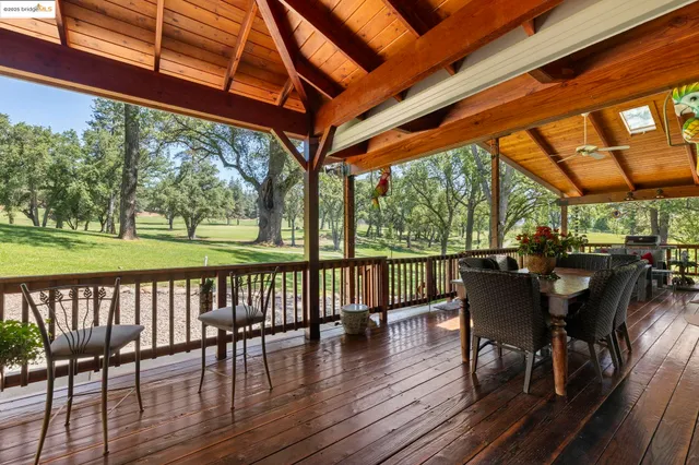 a view of a chairs and table in patio with wooden floor